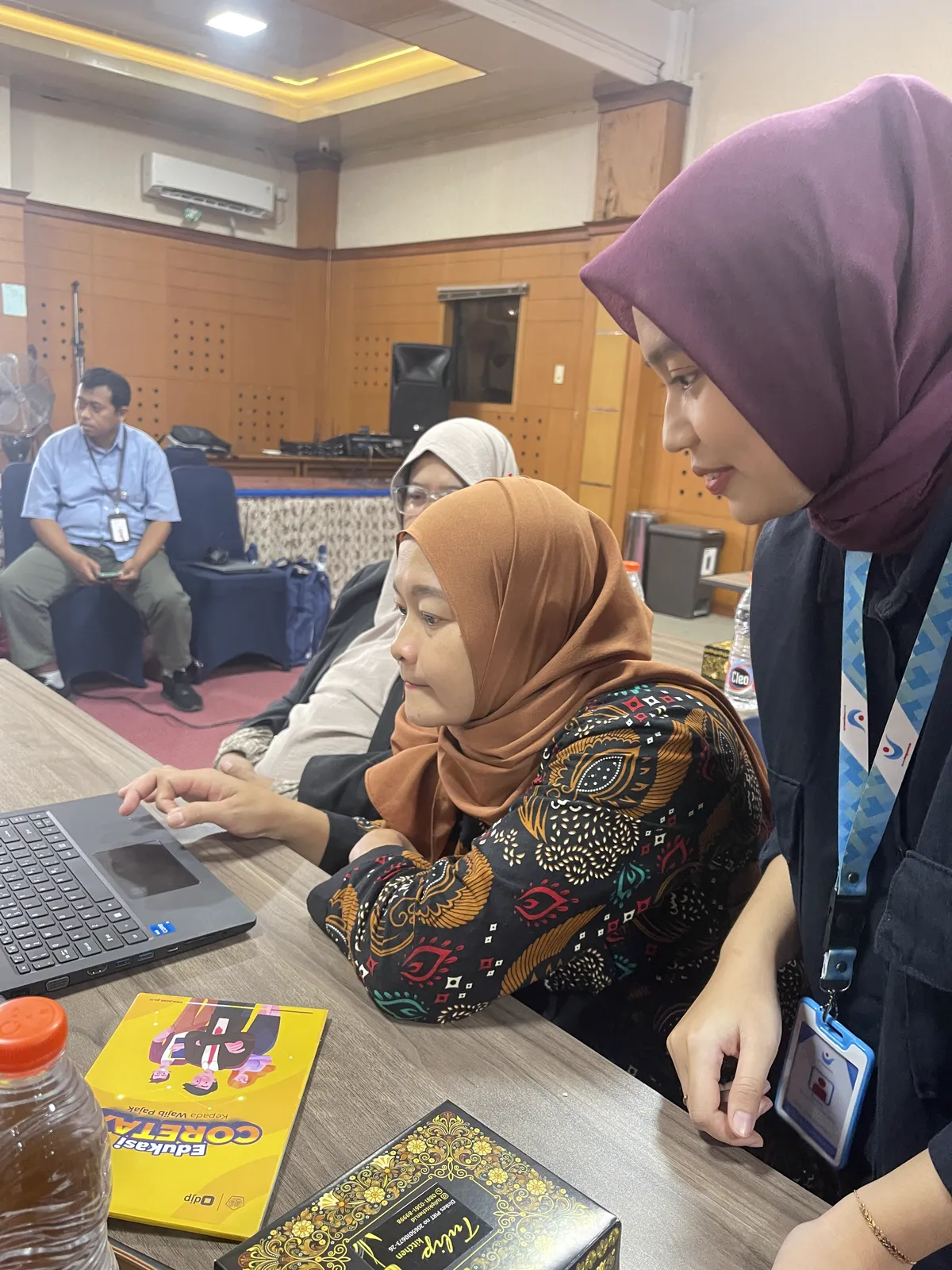 Tim Bantu Pengusaha mendampingi pemilik usaha mengolah data di laptop