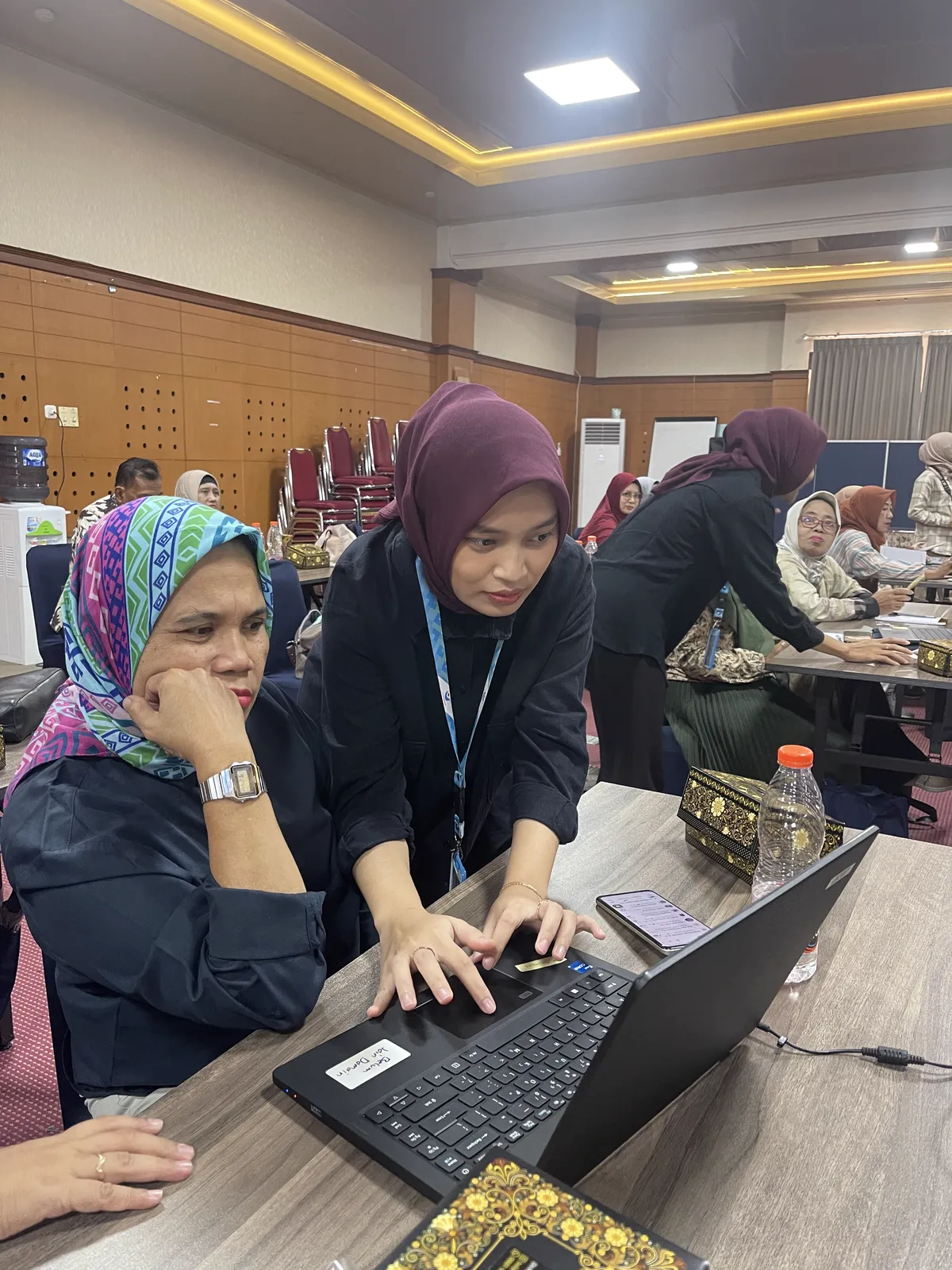 Tim Bantu Pengusaha mendampingi peserta menyusun laporan di laptop